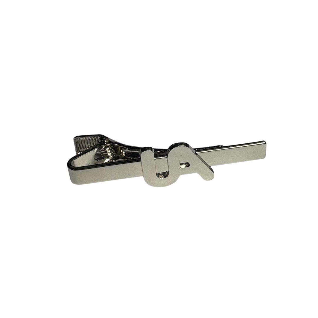 Silver metal tie bar with raised UA logo, shown on a white background.